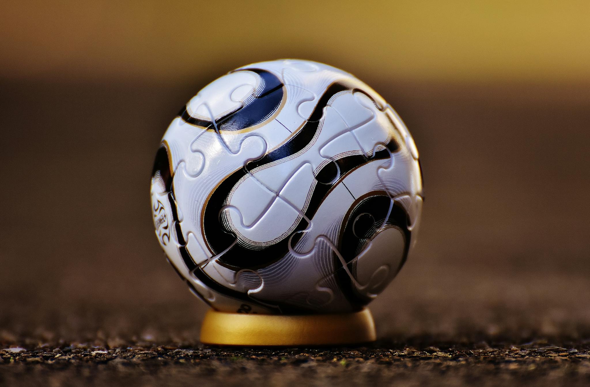 Macro shot of a soccer-themed puzzle ball on a stand, showcasing intricate details.